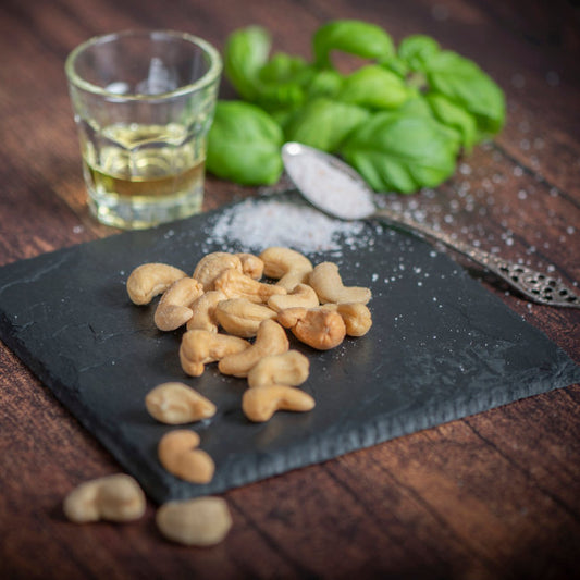 Cashews geröstet und gesalzen auf Schieferplatte dekoriert mit Öl und Salz