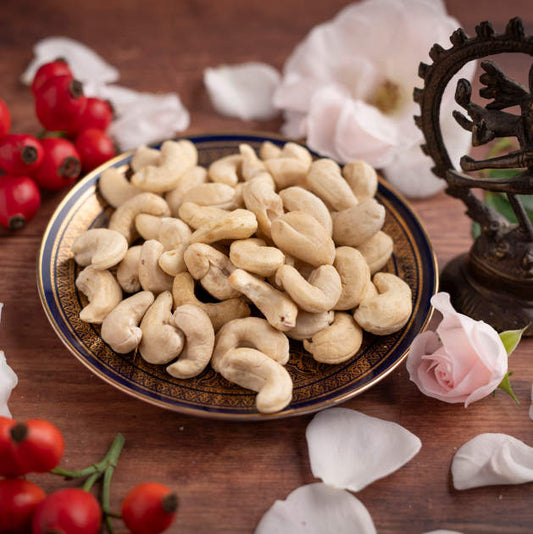 Seitanansicht nussmart Cashew aus Indien Naturell Größe W 320 . Szenenbild mit Deko. Cashewkerne in Schale mit Blumendekoration um der Schale
