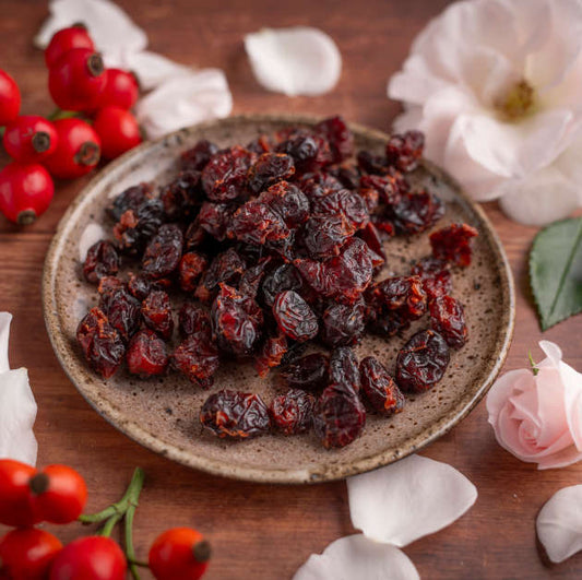 Ganze Cranberries online bei nussmart kaufen. Cranberries in Schale Szenenbild. Dekoriert mit Blumen. Schale auf Holztisch