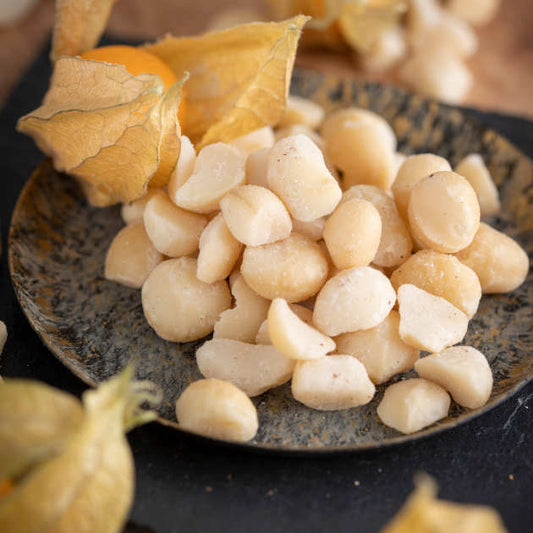 Macadamia Style 2 aus Südafrika. Dekoriert in Schale auf Schieferplatte und Blüten drumherum