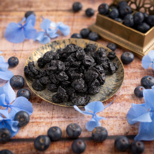 Getrocknete Blaubeeren von nussmart. Seitenansicht mit Szene. Blaue Blumenblüten um die Beeren