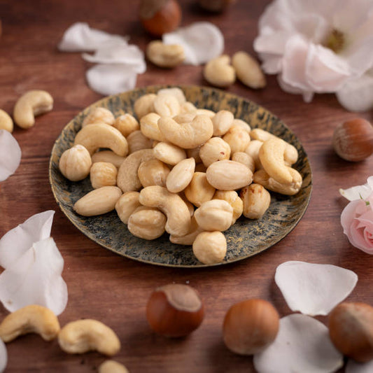 Paleo Sammler Mix von nussmart. Ansicht Nüsse in Schale auf Holztisch und dekoriert mit Blumenblätter