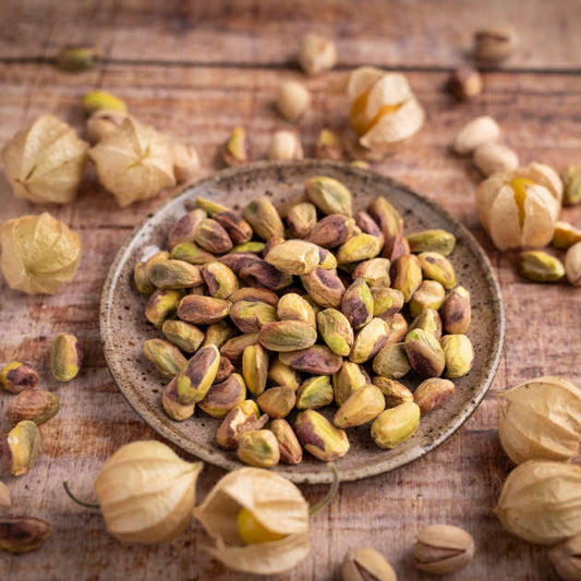 Pistazienkerne aus Spanien dekoriert in Schale auf Holztisch