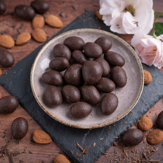 nussmart Schoko Mandel Zartbitterschokoklade in Schale auf Schieferplatte dekoriert.