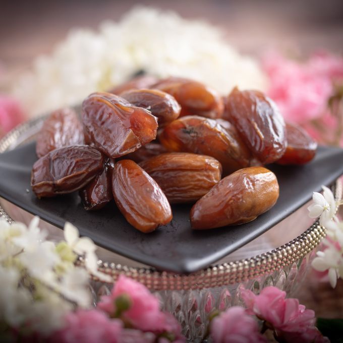 Datteln aus Algerien. Deglet Nour. Auf Schale mit Deko drumherum